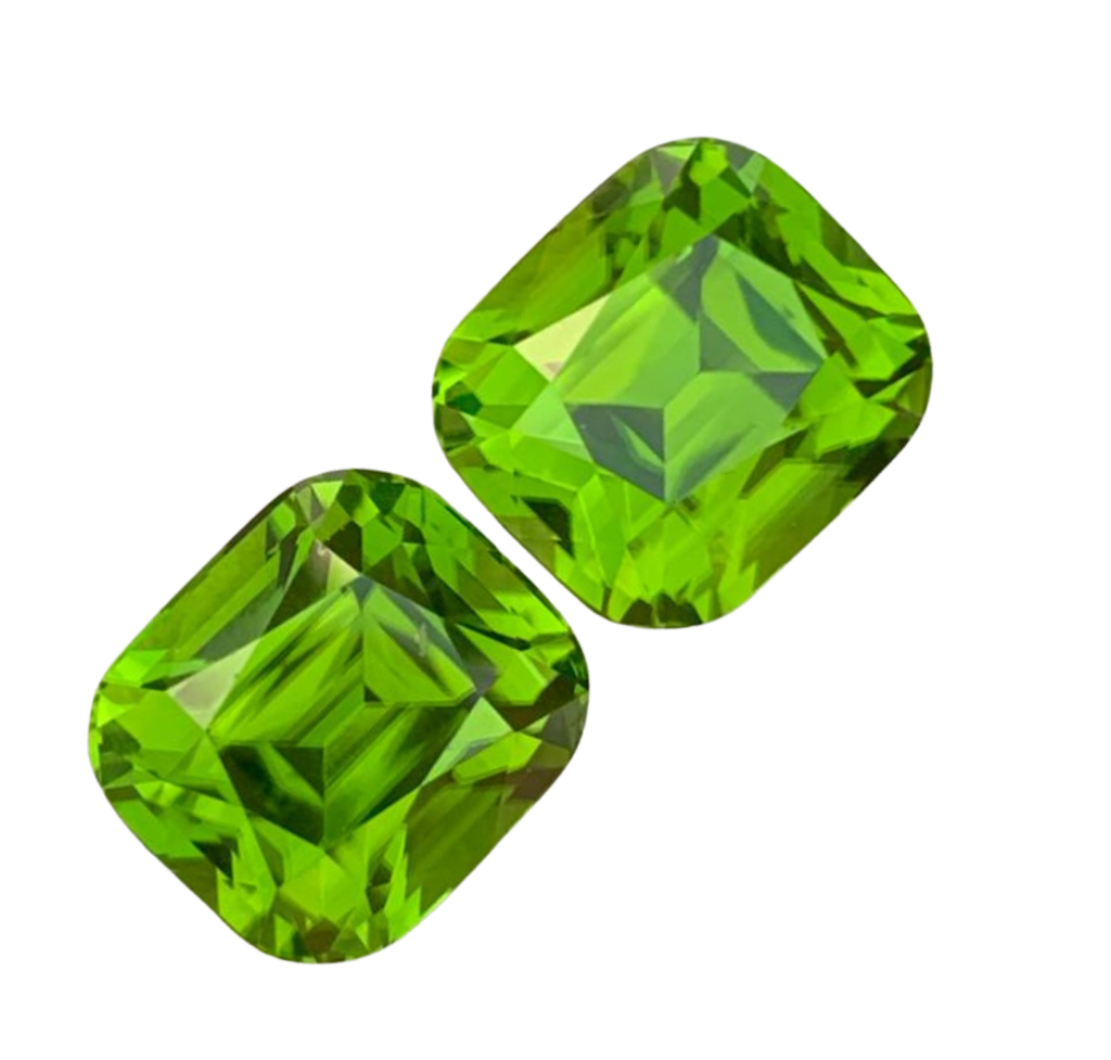 Two bright green cushion-cut faceted peridot gemstones on a plain white background.