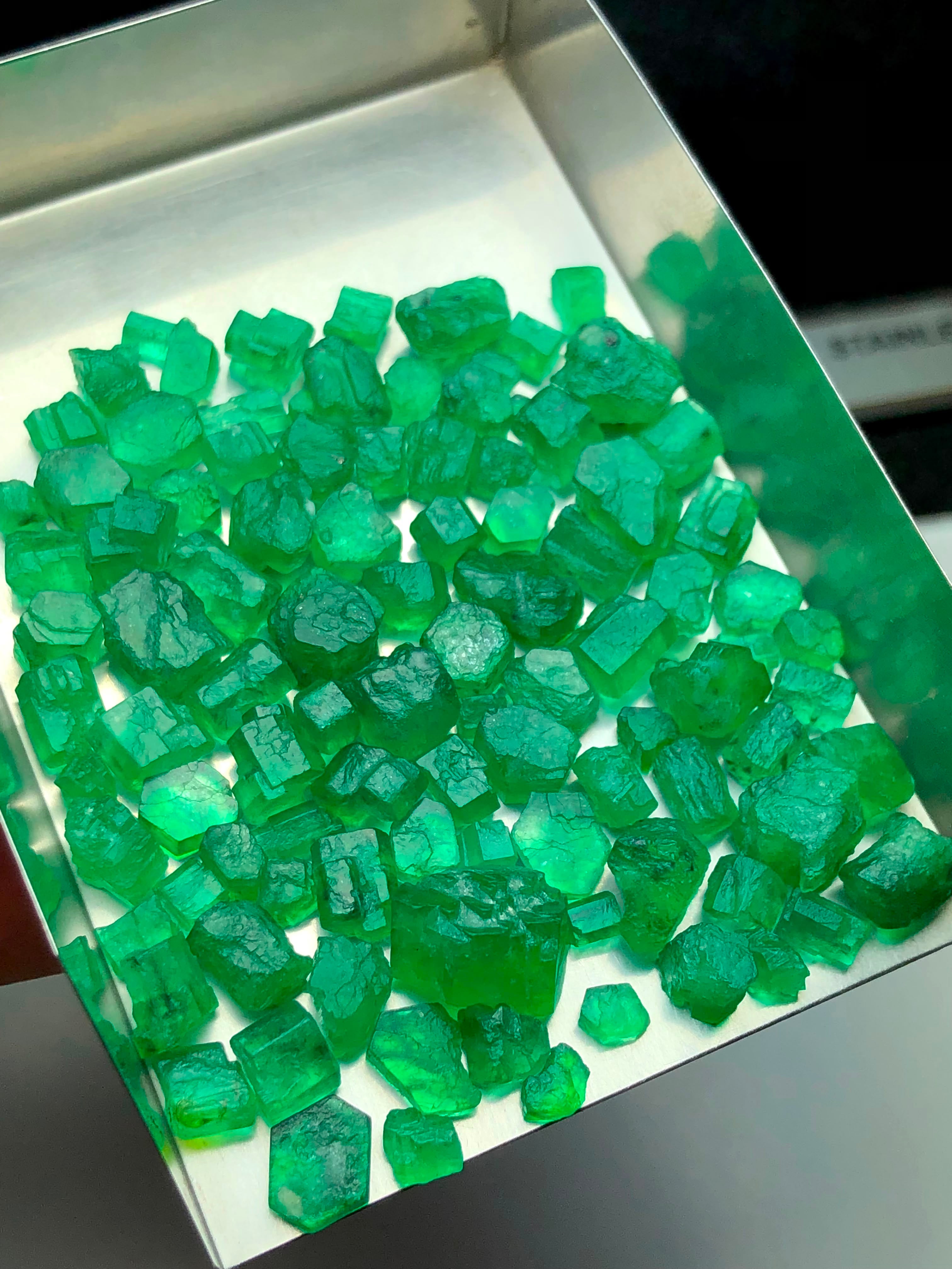 A close-up of many translucent green emerald gemstone