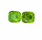 Two round cushion-cut green gemstones with faceted edges, displayed side-by-side on a plain white background.